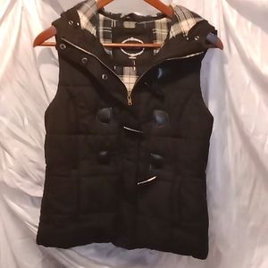 Black puffy vest with blue/green/black flannel  interior and a hood